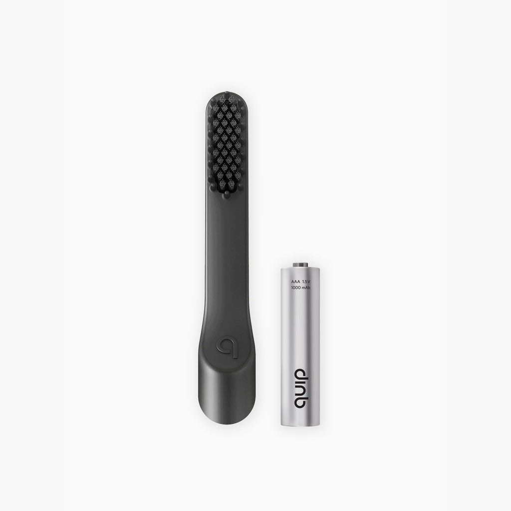 Black handheld tool with bristle head and silver cylindrical battery on a white background